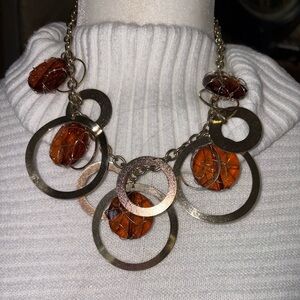 GOLD STATEMENT NECKLACE WITH MUTI CIRCLES AND AMBER COLORED CAGED STONES.